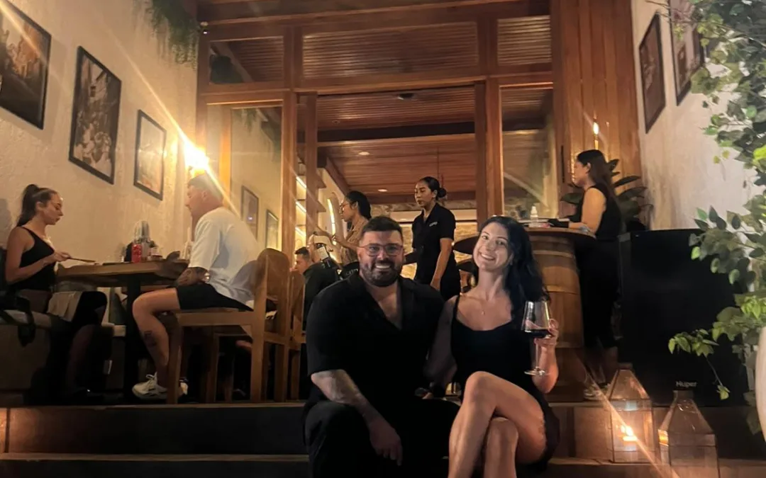 Mitch and Judith, owners of CAVO Bar & Bistro, sitting on the front steps of their Italian restaurant in Pecatu, Uluwatu at night