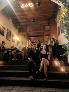 Mitch and Judith, owners of CAVO Bar & Bistro, sitting on the front steps of their Italian restaurant in Pecatu, Uluwatu at night